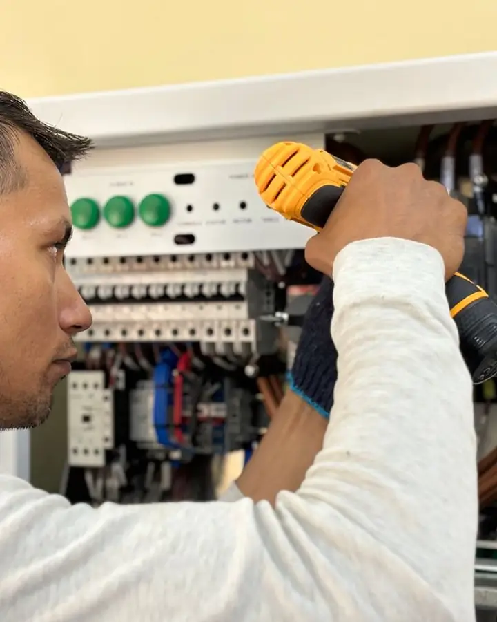 An electrician working on a panel